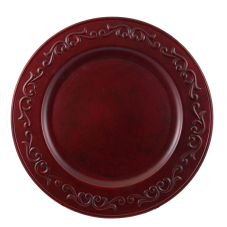 A red acrylic charger with decorative flourishes around the rim.